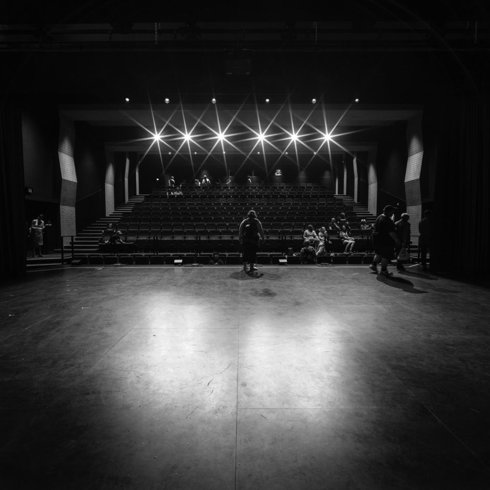 En n tom teaterscen och -sal i svart och vitt.