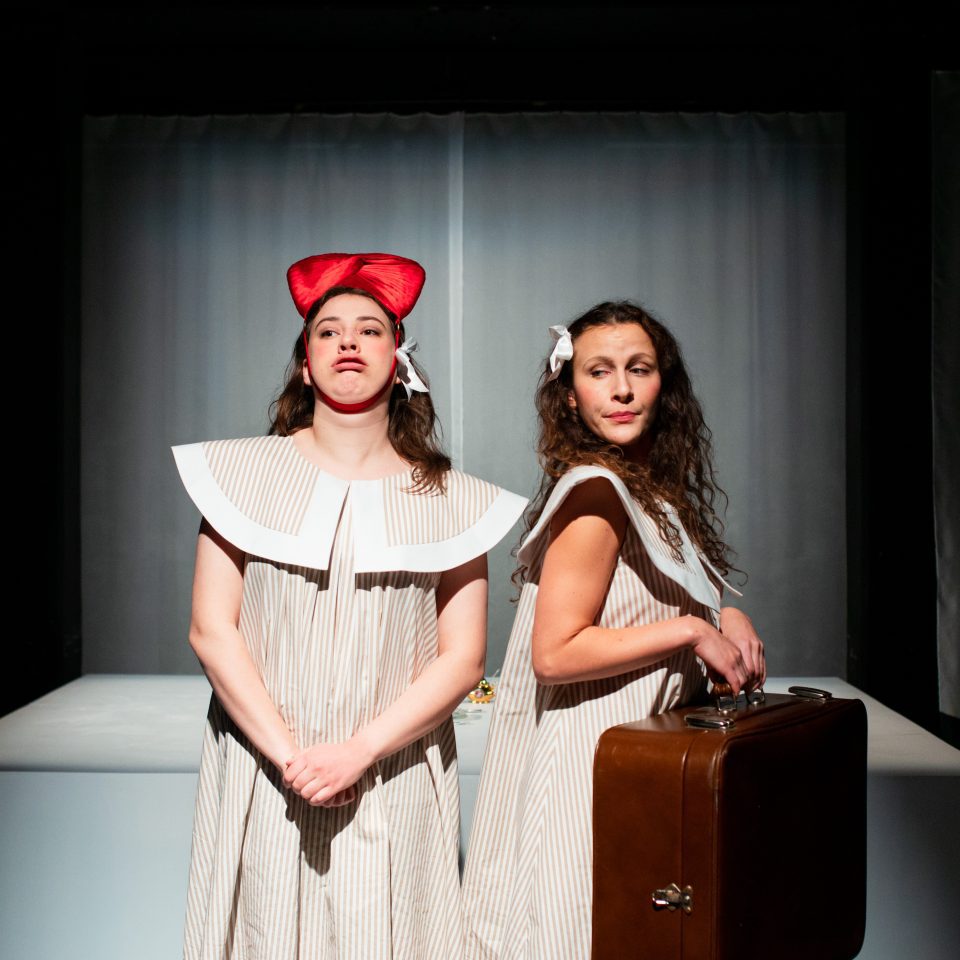 Mathilda Kruse and Oksana Lommi as Mannerheim's daughters, both wearing white dresses and one carrying a big leather travel case.